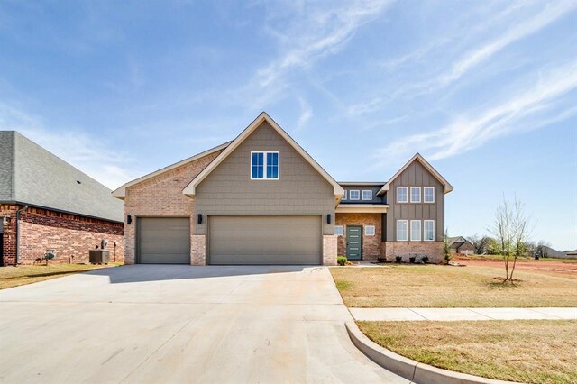 11616 NW 106th St, Yukon, OK 73099 - view of front of property with brick siding, driveway, board and batten siding, a front yard, and cooling unit