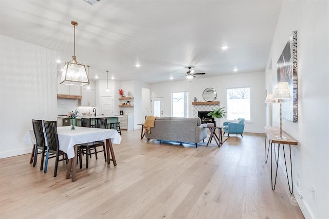 11616 NW 106th St, Yukon, OK 73099 - dining area featuring a ceiling fan, light wood finished floors, a fireplace, baseboards, and recessed lighting