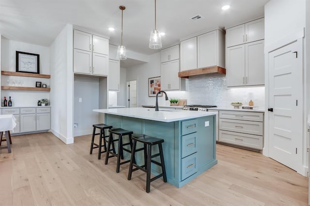 11616 NW 106th St, Yukon, OK 73099 - kitchen featuring light wood finished floors, light countertops, tasteful backsplash, a sink, and recessed lighting