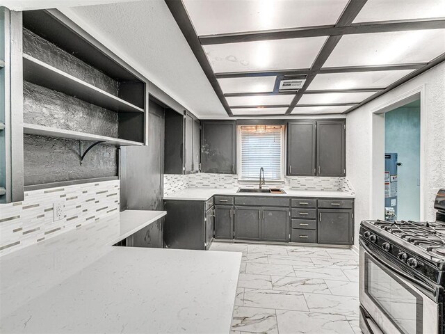 908 N Barta Ave, Prague, OK 74864 - kitchen featuring gas stove, a sink, light marble finish flooring, and light countertops