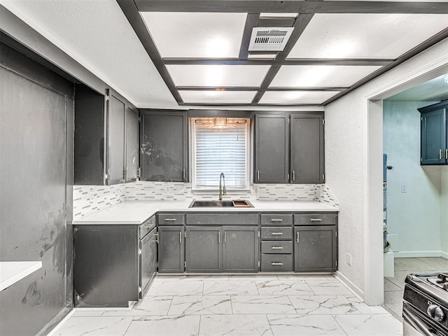 908 N Barta Ave, Prague, OK 74864 - kitchen featuring a sink, light marble finish floors, light countertops, and backsplash