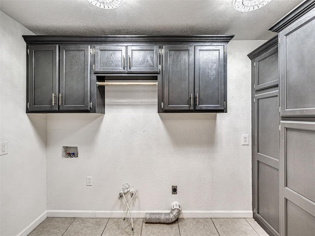 908 N Barta Ave, Prague, OK 74864 - laundry room with baseboards, hookup for a washing machine, electric dryer hookup, cabinet space, and light tile patterned flooring