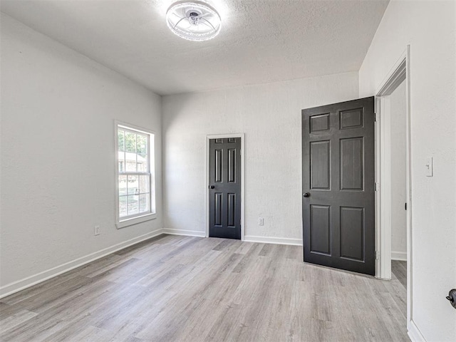 908 N Barta Ave, Prague, OK 74864 - unfurnished room featuring wood finished floors, a textured ceiling, and baseboards