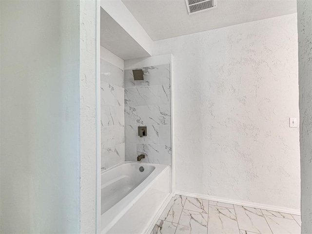 908 N Barta Ave, Prague, OK 74864 - bathroom with a textured wall, marble look tiles, baseboards, and washtub / shower combination