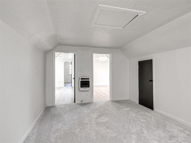 908 N Barta Ave, Prague, OK 74864 - bonus room with heating unit, vaulted ceiling, a textured ceiling, carpet, and attic access
