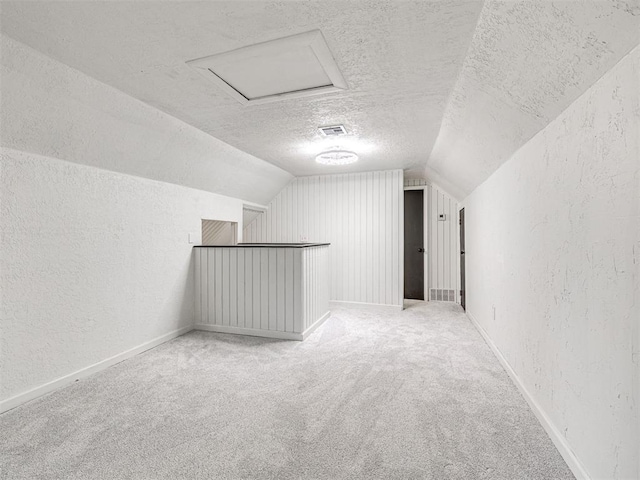 908 N Barta Ave, Prague, OK 74864 - bonus room featuring a textured wall, a textured ceiling, lofted ceiling, carpet, and baseboards
