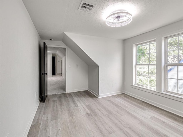 908 N Barta Ave, Prague, OK 74864 - additional living space with a textured ceiling, light wood finished floors, and baseboards