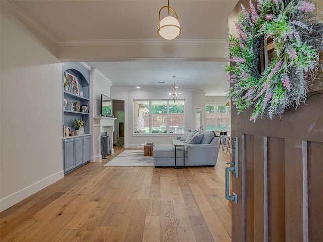 4300 High Range Ln, Edmond, OK 73034 - living room with light wood-style flooring, a fireplace with flush hearth, ornamental molding, baseboards, and a chandelier