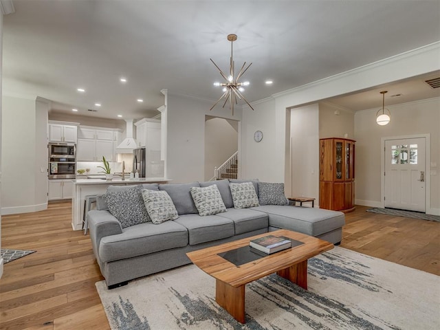 4300 High Range Ln, Edmond, OK 73034 - living room featuring light wood-style flooring, ornamental molding, recessed lighting, a chandelier, and baseboards