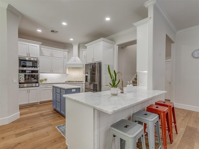 4300 High Range Ln, Edmond, OK 73034 - kitchen with appliances with stainless steel finishes, custom range hood, crown molding, white cabinetry, and recessed lighting