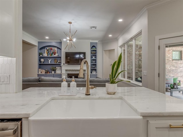4300 High Range Ln, Edmond, OK 73034 - kitchen with a sink, open floor plan, ornamental molding, light stone countertops, and recessed lighting