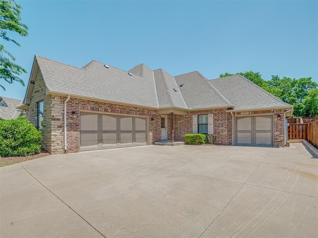 4300 High Range Ln, Edmond, OK 73034 - view of front of home with an attached garage, concrete driveway, roof with shingles, and brick siding