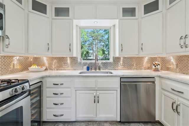 1109 Tedford Way, Nichols Hills, OK 73116 - kitchen featuring appliances with stainless steel finishes, a sink, beverage cooler, white cabinetry, and decorative backsplash