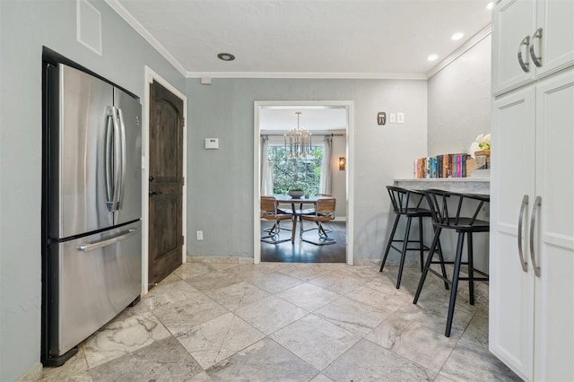 1109 Tedford Way, Nichols Hills, OK 73116 - kitchen featuring freestanding refrigerator, ornamental molding, white cabinets, and a chandelier
