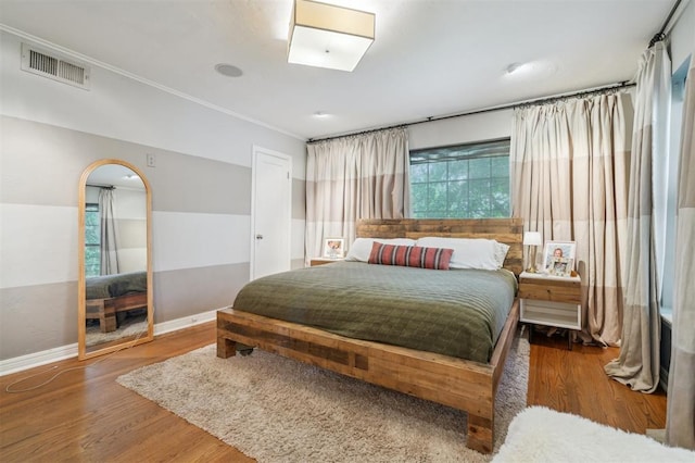 1109 Tedford Way, Nichols Hills, OK 73116 - bedroom featuring wood finished floors, baseboards, crown molding, and arched walkways