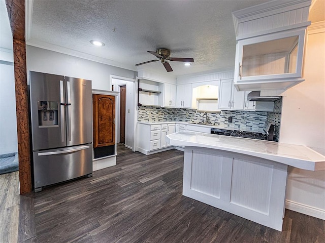 1515 S Reno Ave, El Reno, OK 73036 - kitchen featuring stainless steel refrigerator with ice dispenser, a peninsula, a ceiling fan, white cabinets, and backsplash