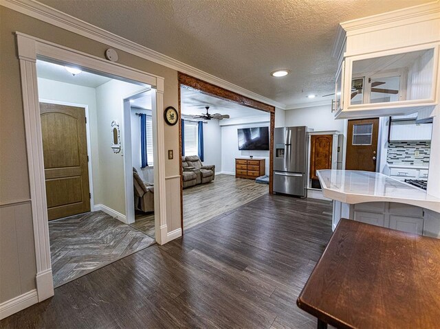 1515 S Reno Ave, El Reno, OK 73036 - kitchen with stainless steel fridge with ice dispenser, dark wood finished floors, baseboards, ornamental molding, and a textured ceiling