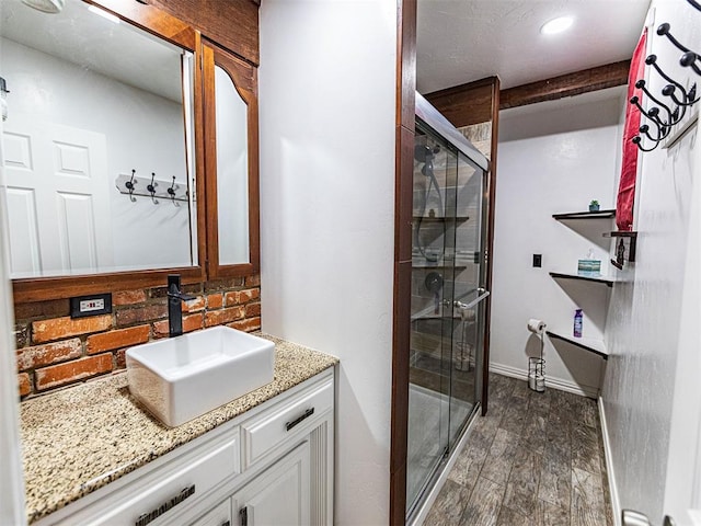 1515 S Reno Ave, El Reno, OK 73036 - bathroom featuring a stall shower, vanity, and wood finished floors