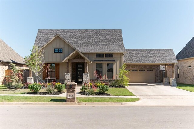 8421 NW 130th Ter, Oklahoma City, OK 73142 - view of front facade featuring board and batten siding, an attached garage, concrete driveway, and roof with shingles