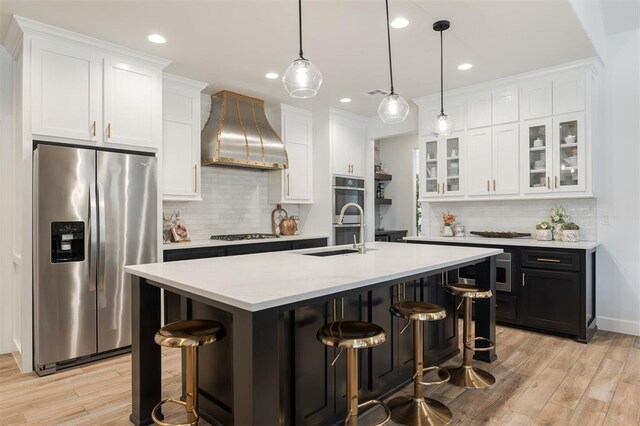 8421 NW 130th Ter, Oklahoma City, OK 73142 - kitchen with appliances with stainless steel finishes, wall chimney range hood, backsplash, light wood-type flooring, and recessed lighting