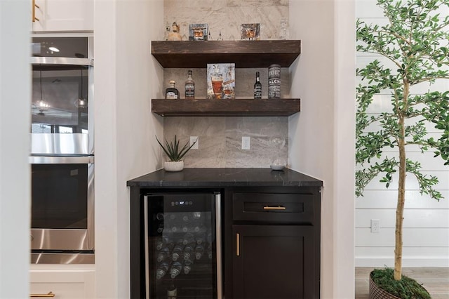 8421 NW 130th Ter, Oklahoma City, OK 73142 - indoor dry bar with wine cooler, stainless steel double oven, backsplash, and wood finished floors