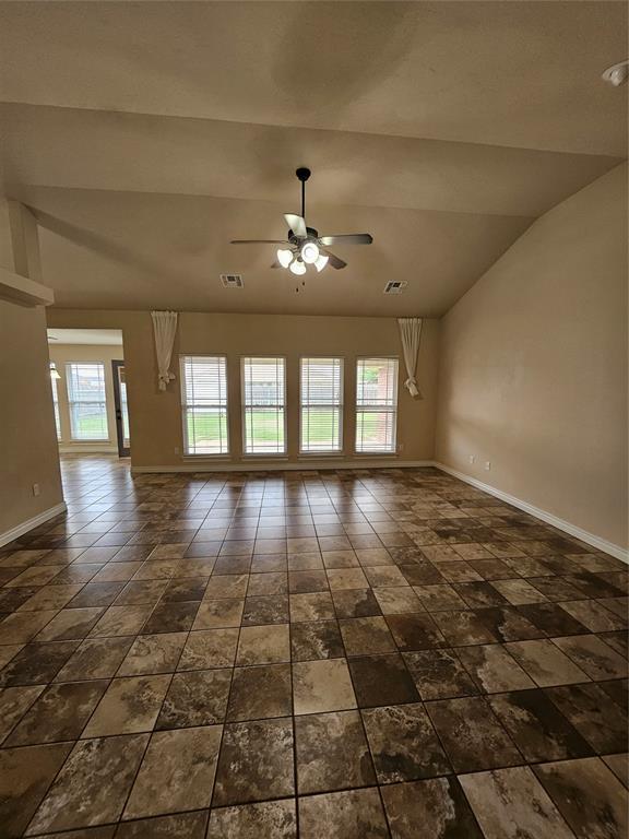 1801 Caribou St, Altus, OK 73521 - spare room with baseboards, a ceiling fan, and vaulted ceiling