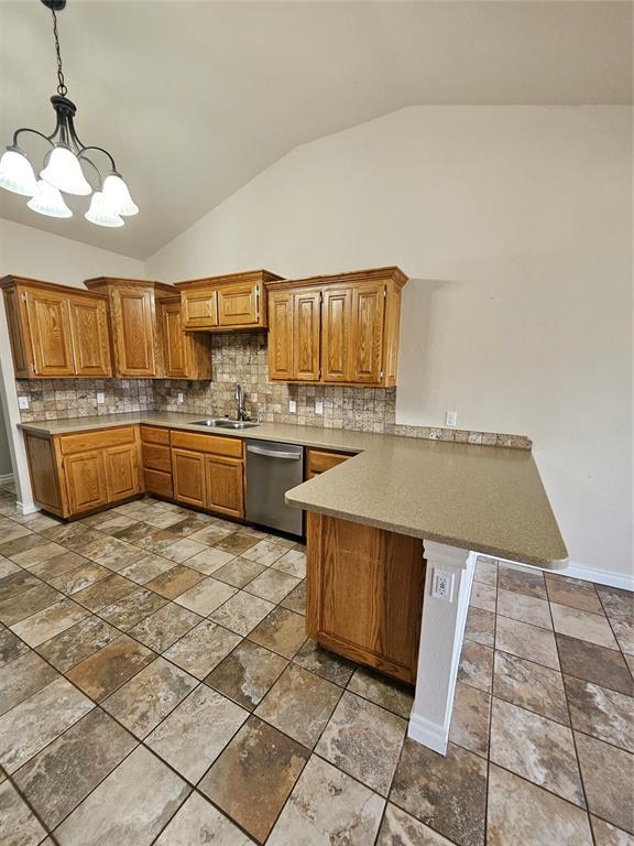 1801 Caribou St, Altus, OK 73521 - kitchen with dishwasher, a peninsula, a sink, lofted ceiling, and decorative backsplash