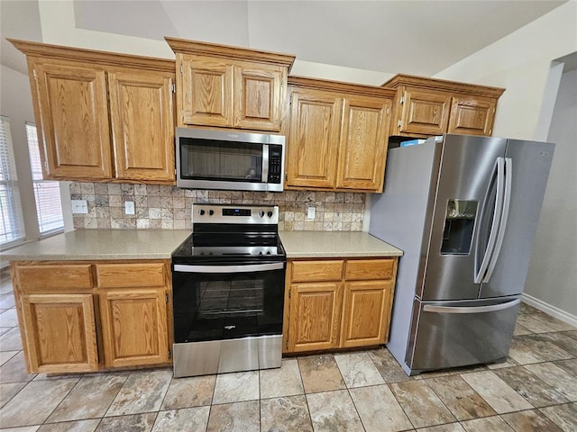 1801 Caribou St, Altus, OK 73521 - kitchen featuring stainless steel appliances, decorative backsplash, light countertops, baseboards, and brown cabinets