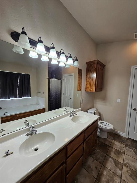 1801 Caribou St, Altus, OK 73521 - full bath featuring a garden tub, toilet, double vanity, and a shower with curtain