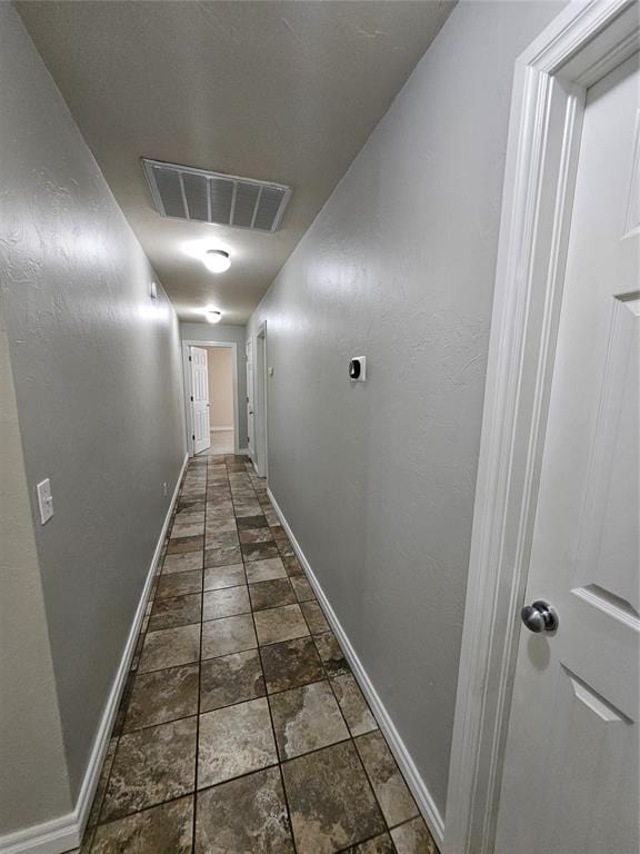 1801 Caribou St, Altus, OK 73521 - hallway featuring baseboards and dark stone finish floors