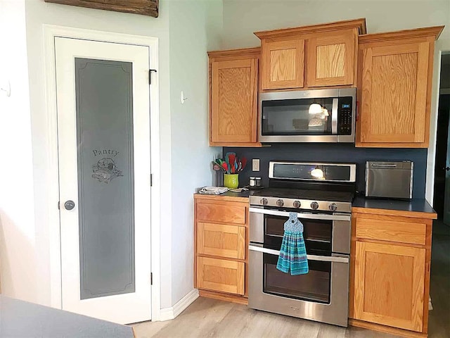 14452 Ns 3630th Rd, Sasakwa, OK 74867 - kitchen featuring stainless steel appliances, light wood-style floors, dark countertops, and baseboards