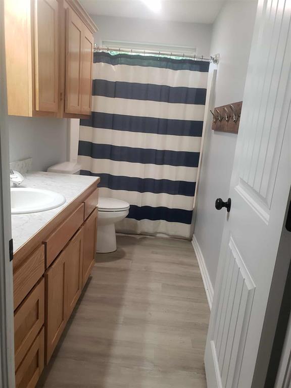 14452 Ns 3630th Rd, Sasakwa, OK 74867 - full bathroom featuring wood finished floors, vanity, toilet, a shower with curtain, and baseboards