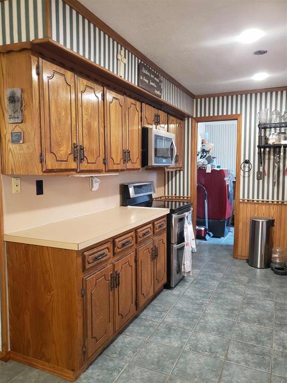 14452 Ns 3630th Rd, Sasakwa, OK 74867 - kitchen featuring appliances with stainless steel finishes, brown cabinetry, and light countertops