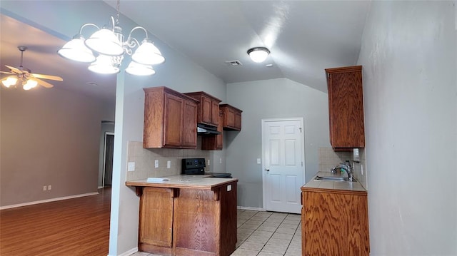 2338 Serenade Dr, Midwest City, OK 73130 - kitchen featuring range with electric stovetop, decorative backsplash, a peninsula, ceiling fan, and under cabinet range hood
