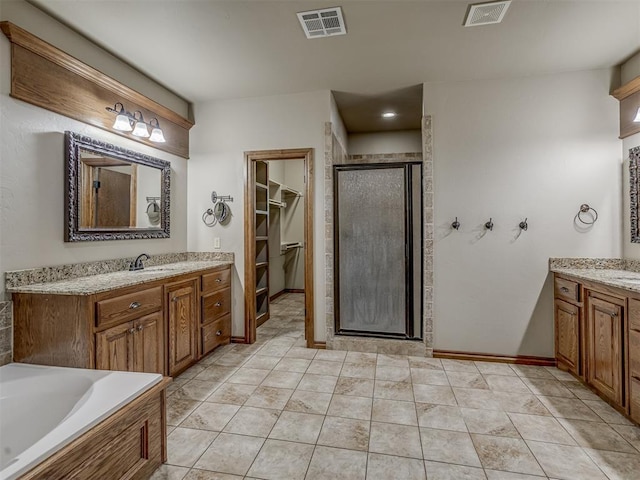 1960 Bermuda Dr, Newcastle, OK 73065 - full bathroom with a stall shower, two vanities, a walk in closet, a tub to relax in, and baseboards