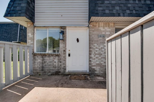 view of exterior entry with brick siding