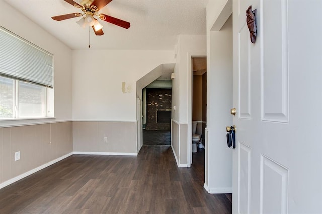 empty room featuring ceiling fan, wood finished floors, and baseboards