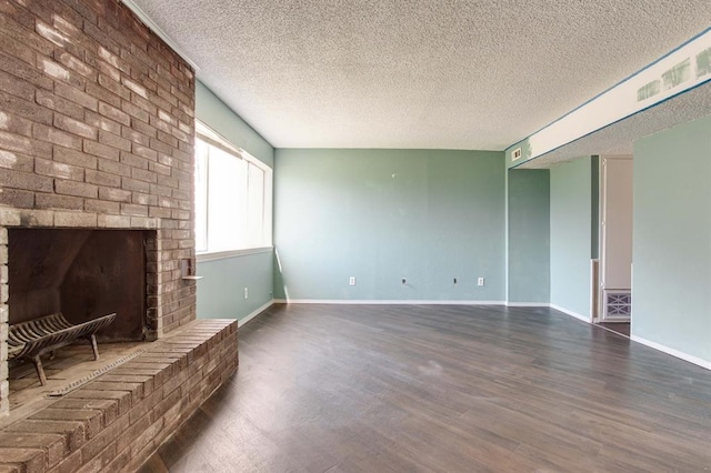 unfurnished living room featuring wood finished floors, a textured ceiling, baseboards, and a fireplace