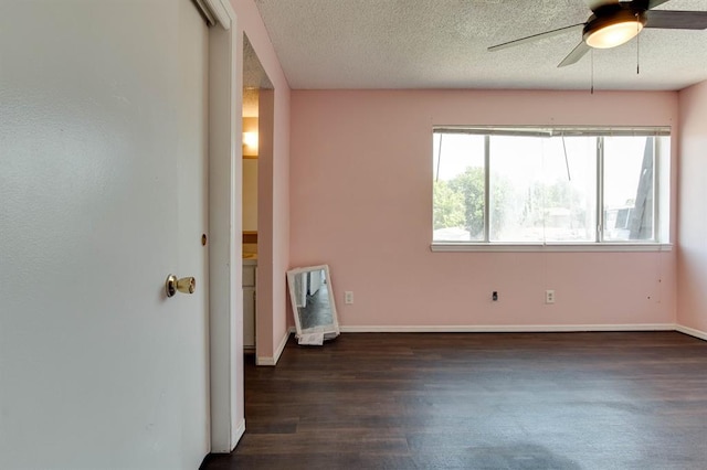 empty room featuring ceiling fan, wood finished floors, a textured ceiling, baseboards, and heating unit