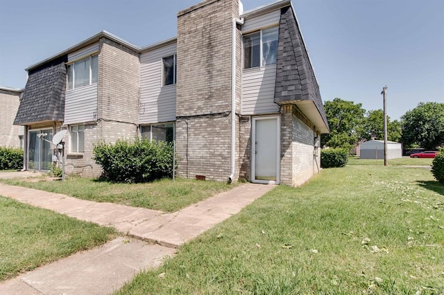 view of front of home featuring brick siding and a front lawn