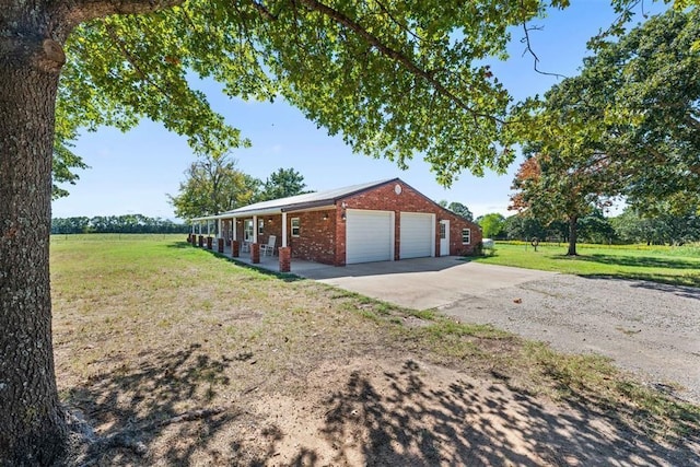 20302 Kings Rd, Shawnee, OK 74801 - view of side of property with brick siding, a yard, concrete driveway, and covered porch