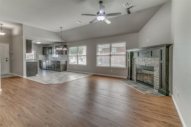 4108 NW 154th St, Edmond, OK 73013 - unfurnished living room with vaulted ceiling, wood finished floors, a stone fireplace, and baseboards