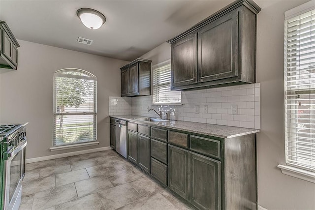 4108 NW 154th St, Edmond, OK 73013 - kitchen with a sink, stainless steel appliances, dark brown cabinetry, decorative backsplash, and baseboards