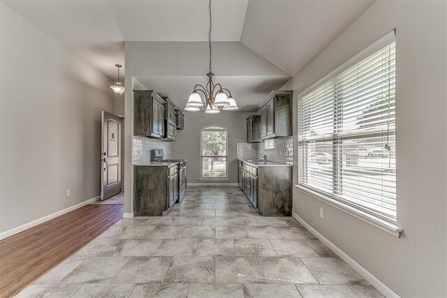 4108 NW 154th St, Edmond, OK 73013 - kitchen featuring gas range, tasteful backsplash, lofted ceiling, a chandelier, and baseboards