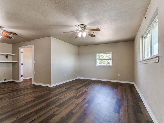 spare room featuring a ceiling fan, dark wood-style floors, a textured ceiling, and baseboards