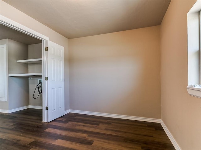 empty room featuring dark wood-style flooring and baseboards