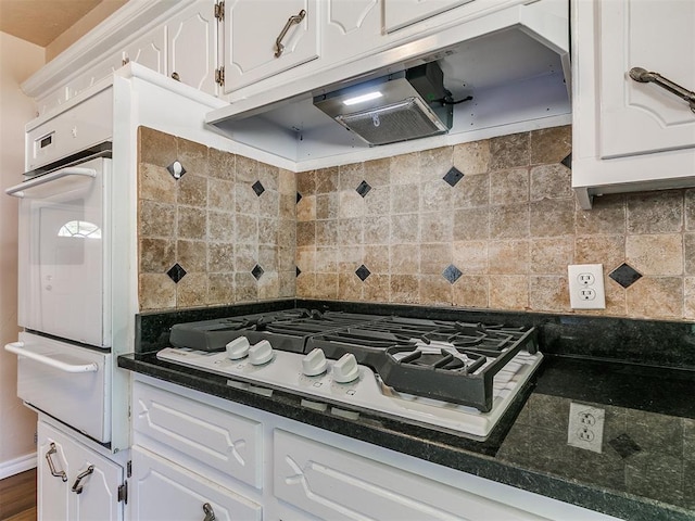 kitchen featuring gas stovetop, a warming drawer, white cabinets, and dark countertops