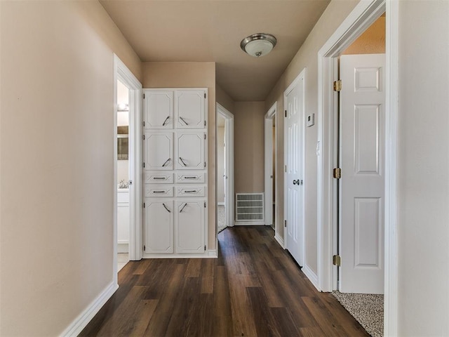 hallway with dark wood-style floors and baseboards