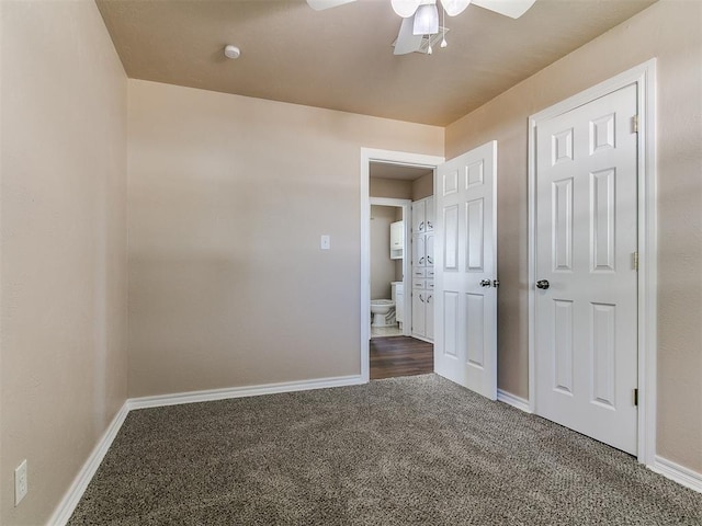 unfurnished bedroom with dark carpet, baseboards, and a ceiling fan