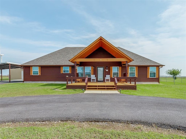 1466 County Rd 1188, Tuttle, OK 73089 - view of front of property with roof with shingles, log veneer siding, covered porch, and a carport